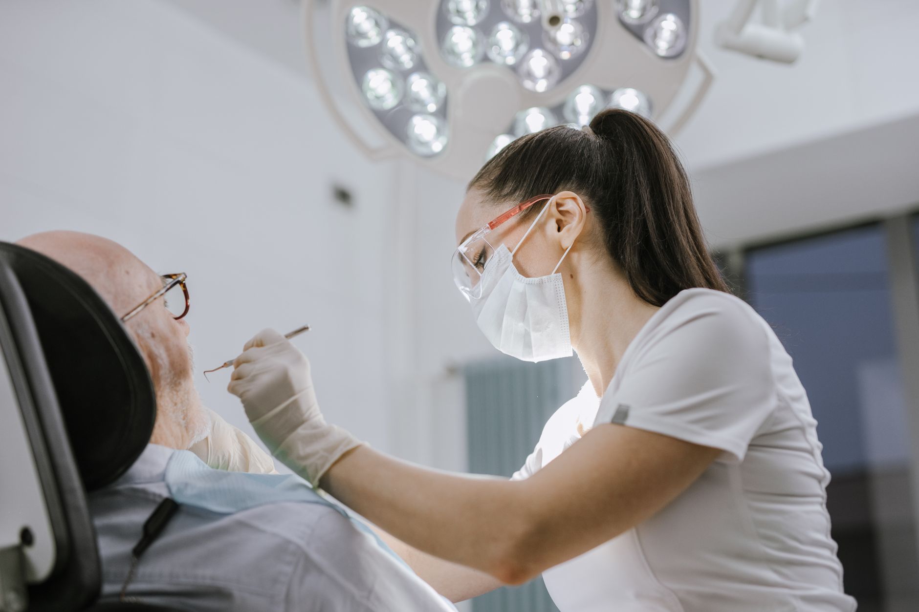 Medicul stomatolog examinează un pacient zâmbitor